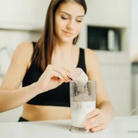 Woman blending MCT powder smoothie for energy boost